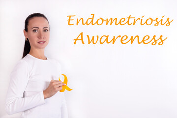 Endometriosis awareness concept. A girl in bright clothes with a yellow ribbon in her hand, as a symbol of awareness.