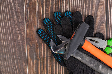 Workers, construction gloves and tool on a wooden background. Clean the house. To make repairs....