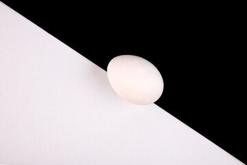 Chicken eggs on a black and white background. Minimalism. Egg on a black and white background. View from the top. Symbol.