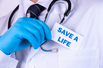 Doctor, man put a card with the text SAVE A LIFE in his pocket. Medical concept.