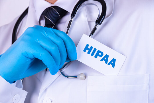 Doctor, man put a card with the text HIPPA, The Health Insurance Portability and Accountability Act of 1996, in his pocket. Medical concept.