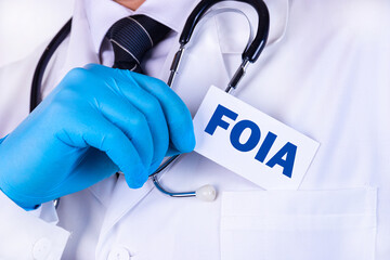 Doctor, man put a card with the text FOIA Freedom of Information Act in his pocket. Medical concept.