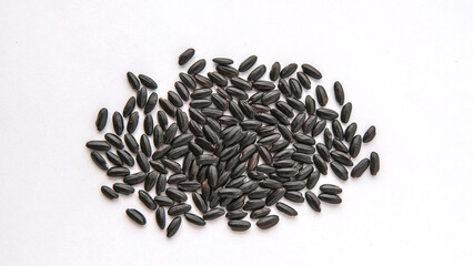 A handful of black rice on a white base.