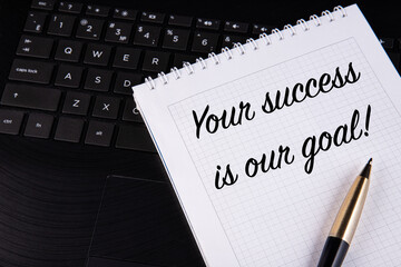 Your success is our goal - written on a notebook with a pen.