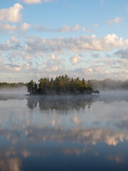 island and fog on a forest lake