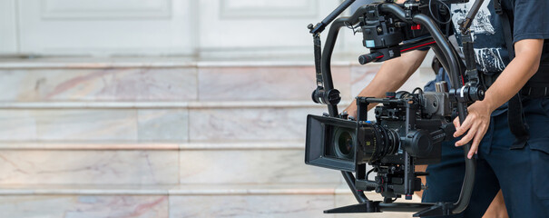 Movie shooting or video production and film crew team with camera equipment. Video camera operator...