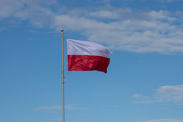 Polskie barwy narodowe, Polska flaga  na tle nieba nad morzem. Bałtyk Kołobrzeg Zachodniopomorskie  - obrazy, fototapety, plakaty