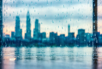 Raindrops clinging to a windowpane, creating a blurred and dreamlike view of the city skyline, offering a moment of tranquility amidst the bustling streets.. AI generated.