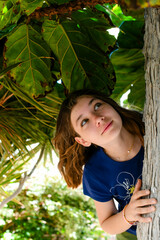 Portrait of a beautiful fashionable teenage girl among the bushes