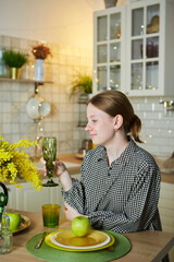 Portrait of a beautiful young girl in the kitchen. Spring flowers in the interior - 788033439