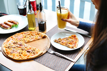 Person Sitting at Table With Plate of Pizza