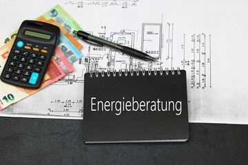 Geldscheine, Bauplan und Taschenrechner mit dem Wort Energieberatung auf einem Notizblock.