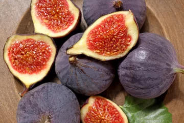  Fresh ripe figs in a wooden bowl on a light background © Atlas
