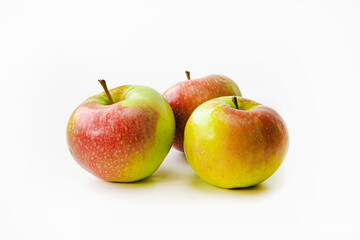 Three red-green ripe apples on a white isolated background