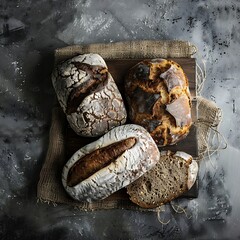 A wooden table is filled with various types of freshly baked loaves of bread, including baguettes