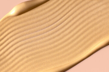 creamy cosmetic texture of golden shining color cosmetic smear close-up
