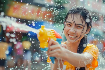 Foto op Plexiglas Happy traveler asian girl wearing summer shirt holding colourful squirt water gun over blur city, Water festival holiday concept © grapestock