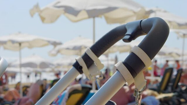Baby stroller on beach with umbrellas in the background in 4k slow motion 120fps