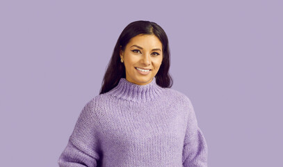 Studio shot of young woman in warm sweater. Portrait of happy beautiful young brunette girl in...