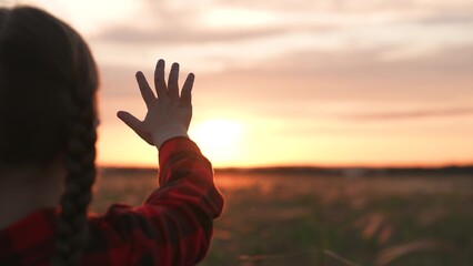 Girl dreamily reaches for sun with hand. Symbolism striving for light wisdom spiritual enlightenment knowledge self-development aspirations. Expectation of miracle dreams inspiration of young child.