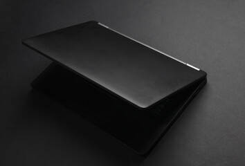 Black closed laptop or ultrabook on a black background