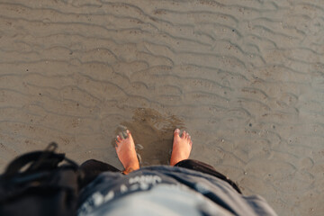 Feet on the sand at the beach at dusk