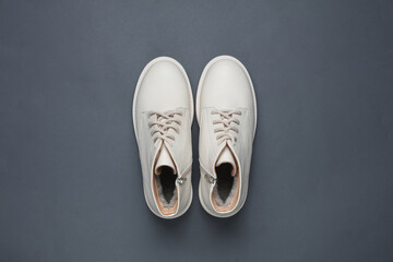 Women's white leather winter boots on a dark gray background. Top view