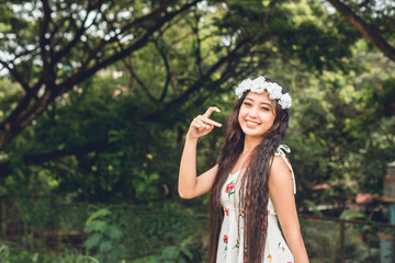 Young Asian Woman in Summer Dress with Floral Headband, Forest Backdrop