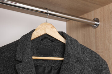 Men's wool coats hanging in the closet on hangers