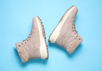 Women's winter boots on a blue background. Top view