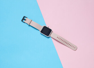 Modern smart watch on a blue-pink background. Top view