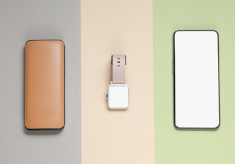 Modern gadgets on a pastel background. Smartphone, smart watch and power bank on a pastel background. White blank screen. Mockup. Top view. Flat lay