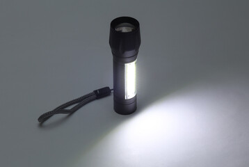 Pocket flashlight on dark gray background.