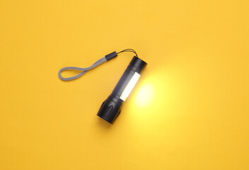 Pocket flashlight on yellow background.