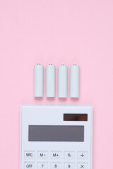 Calculator with AA batteries on a pink background