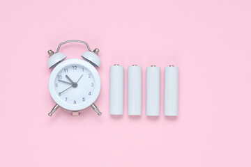 Alarm clock with AA batteries on a pink background