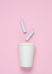 Coffee cup with AA batteries on a pink background
