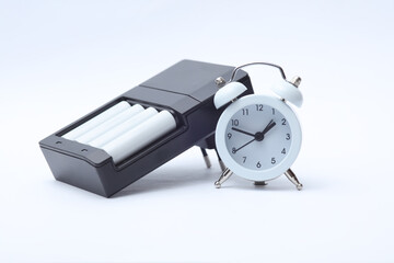 Charger with aa batteries and alarm clock on a white background