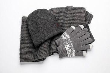 Knitted gloves, scarf  and hat on white background. Top view
