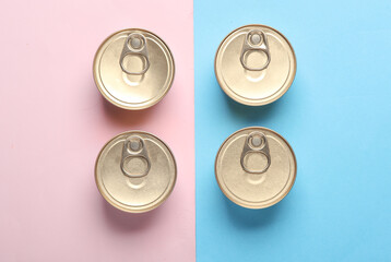 Cans with canned food on pink blue pastel background. Top view. Flat lay