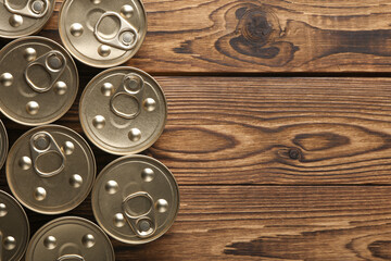 Many Cans with canned food on wooden background. Top view.