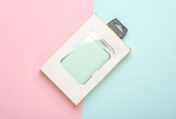 New Plastic power bank in pack on pink blue pastel background. Top view