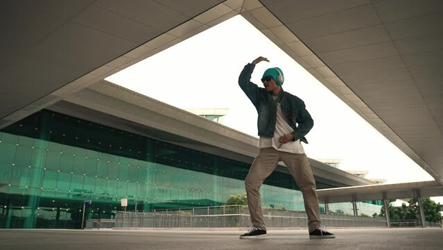 Panorama shot of happy hipster dance together while listen music from headphone at mall. Professional break dancer enjoy perform b boy footstep. Outdoor sport 2024. Modern street dancing. Sprightly.