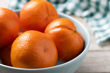 Fresh tangerines in green bowl on wooden table. Close up - 788106413