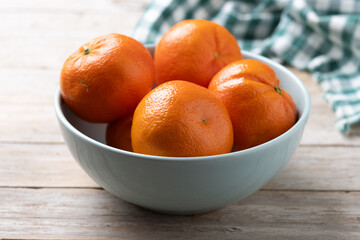Fresh tangerines in green bowl on wooden table - 788106439