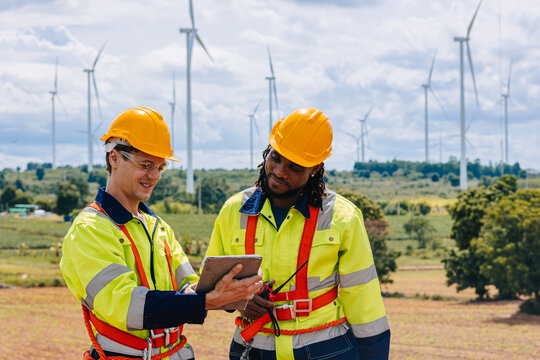 Engineer team working group survey at wind turbine clean power generator service maintenance wind mill outdoor.