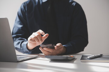 Side view shot of a man's hands using smart phone in interior, rear view of business man hands busy using cell phone at office desk, young male student typing on phone sitting at wooden table, flare