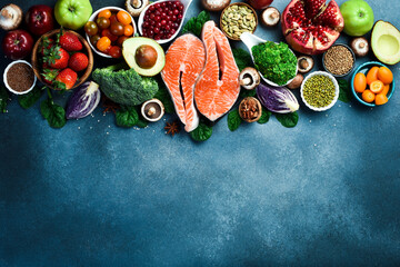 Obraz na płótnie Canvas Healthy food background. Concept of Healthy Food, Fresh Vegetables, fish, Nuts and Fruits. On a concrete background. Top view. Copy space
