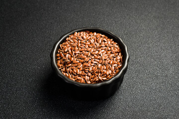 Close-up of flax seeds in a ceramic bowl. Superfood On a dark concrete background. - 788118055
