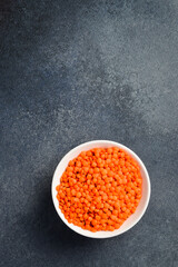 Close-up of lentils in a ceramic bowl. On a dark concrete background. - 788118084